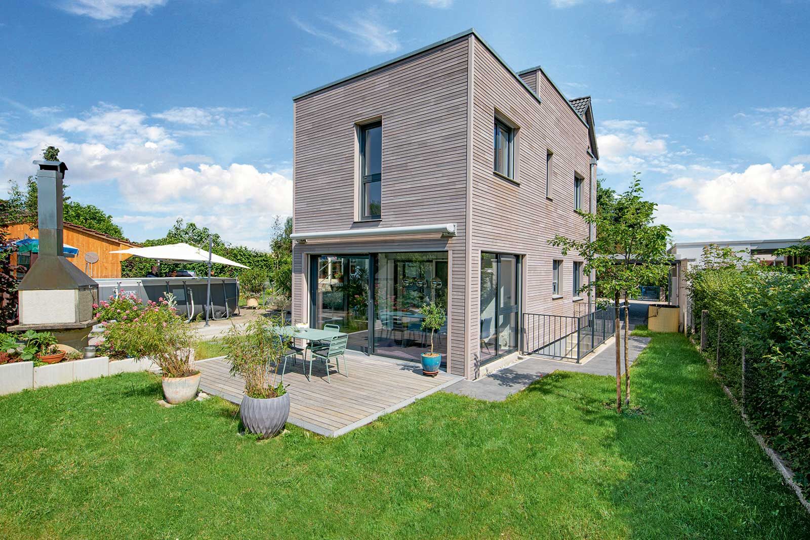 Der moderne Flachdachbau beherbergt im Erdgeschoss eine grosszügige Loggia mit Blick auf die Terrasse und den Garten.